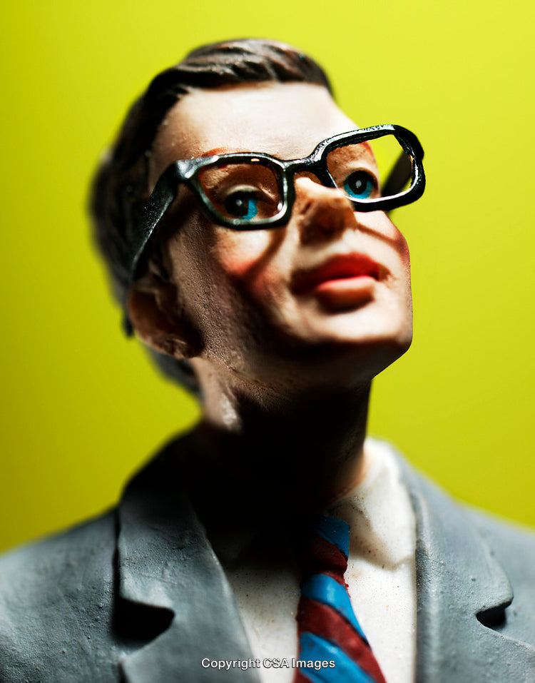 Close-Up of a Plastic Figurine with Glasses on a Yellow Background