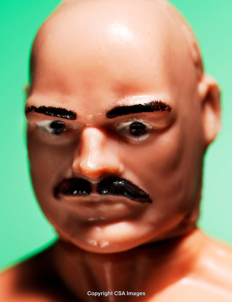 Close-Up of Bald Plastic Toy Figure with Mustache on Green Background