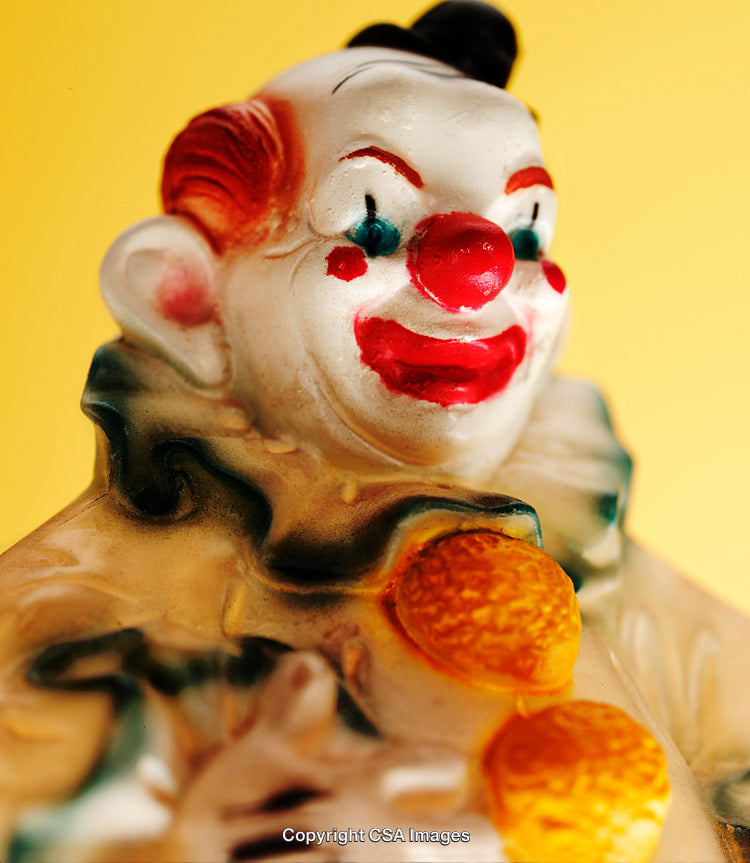 Colorful Toy Clown Figurine with Bright Red Nose and Yellow Background