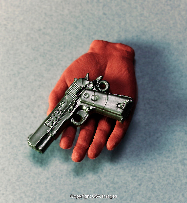 Red Gloved Hand Holding a Toy Firearm on Neutral Background