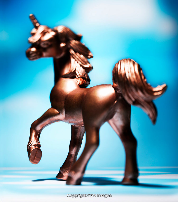 Golden Unicorn Figurine With Blue Background in Bright Lighting