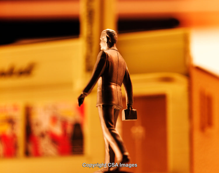 Close-Up of a Miniature Business Figure in Urban Setting with Warm Lighting