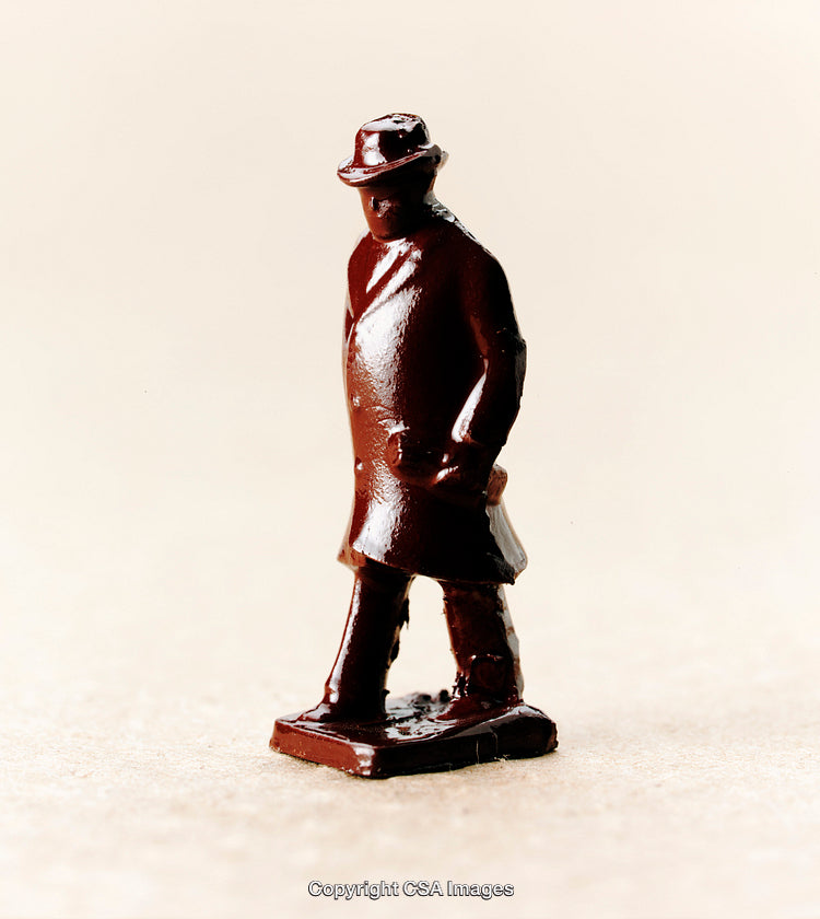 Small Plastic Figurine of Brown-Coated Man on Neutral Surface