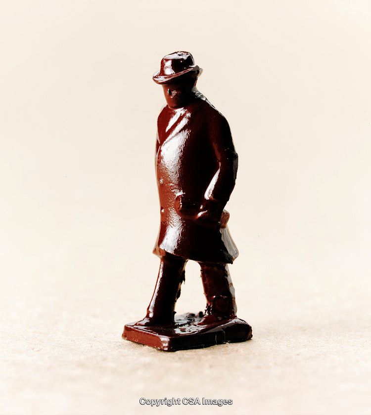 Small Plastic Figurine of Brown-Coated Man on Neutral Surface