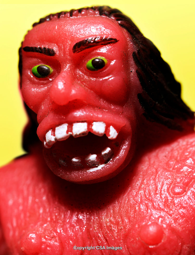 Close-Up of Bright Red Monster Toy with a Vibrant Yellow Background