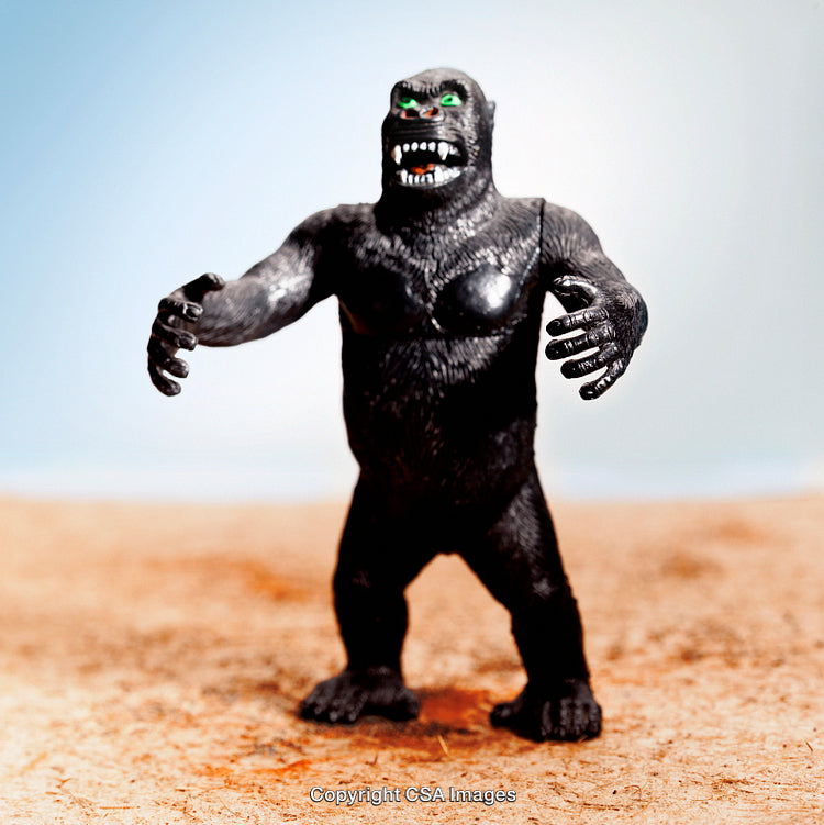 Close-Up of a Fierce Gorilla Figurine on Sand