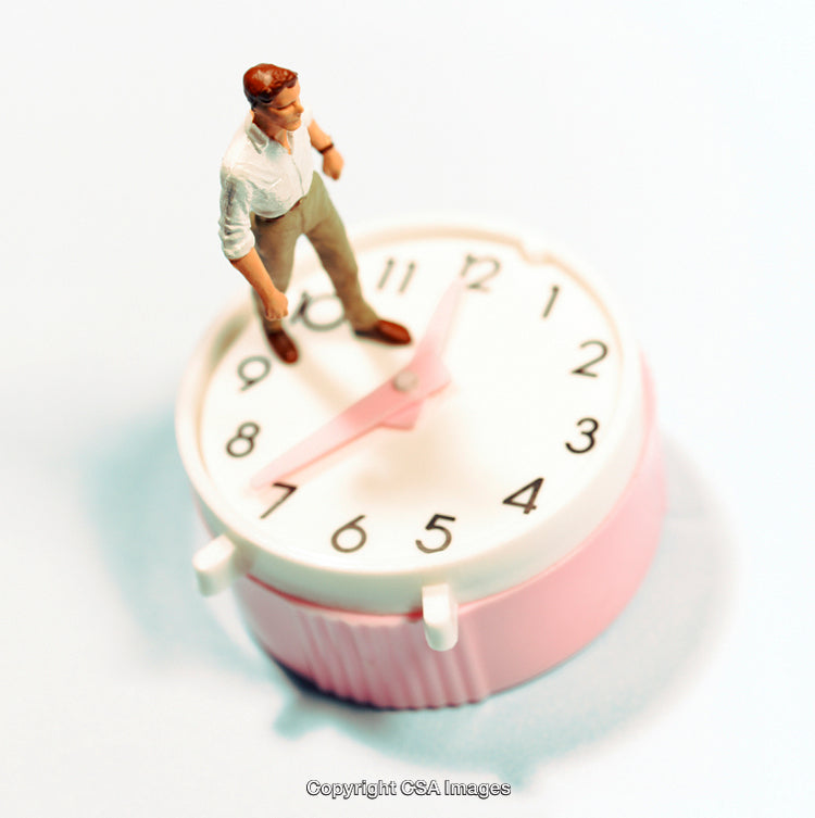 Miniature Figurine Standing on a Clock Representing Time Management Concepts