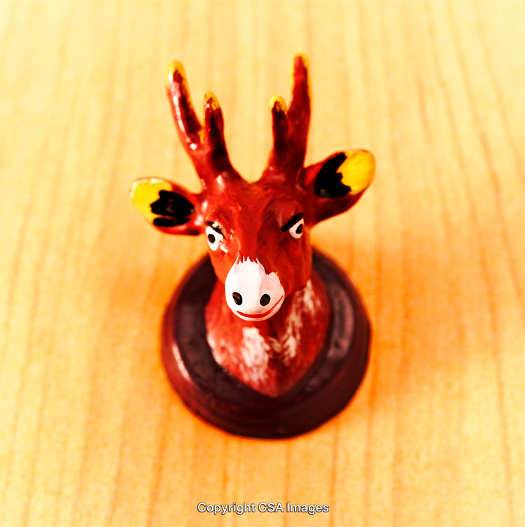 Close-Up of Colorful Deer Figurine on Wooden Surface