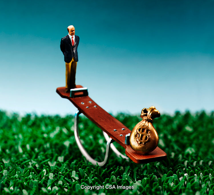 Miniature Businessman on Seesaw Balancing Against a Bag of Wealth