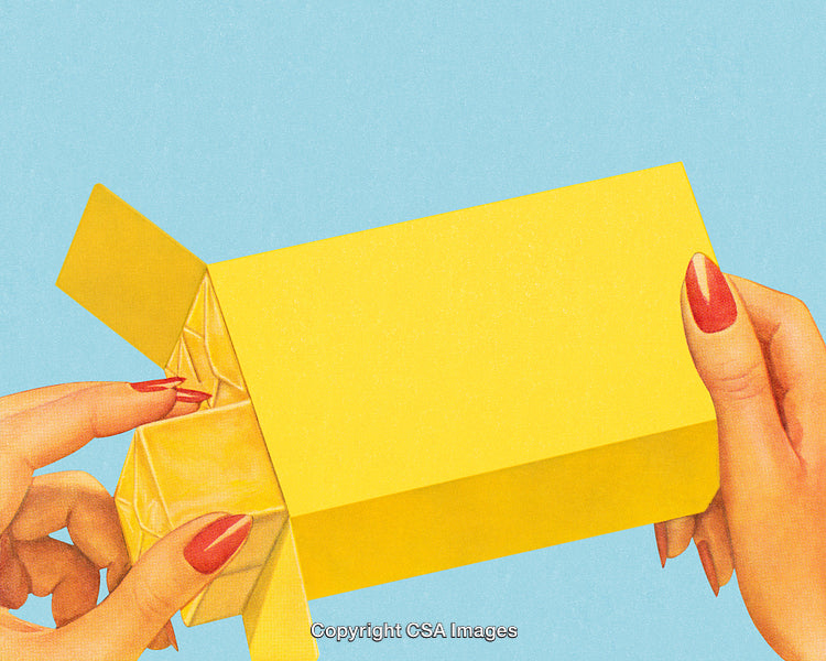 Close-Up of Hands Extracting Item From Bright Yellow Box on Blue Background