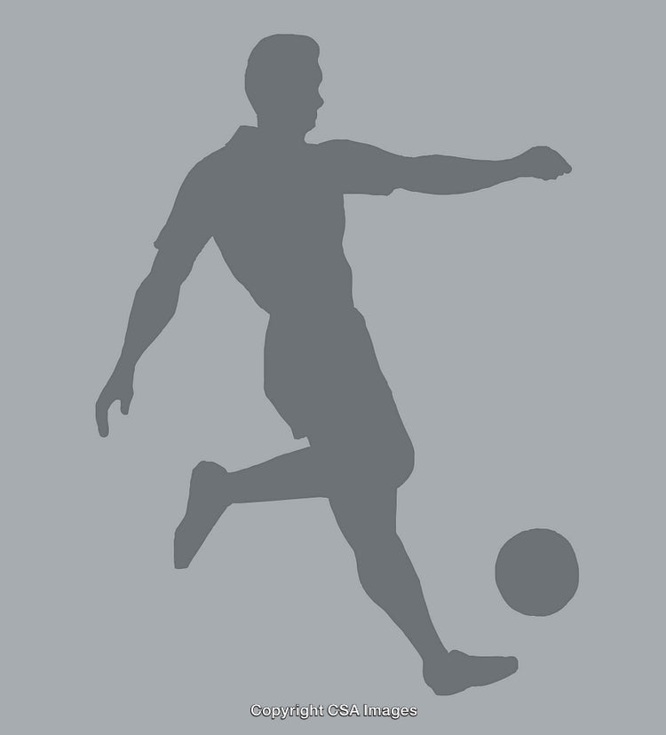 Silhouette of a Soccer Player Kicking a Ball in Action