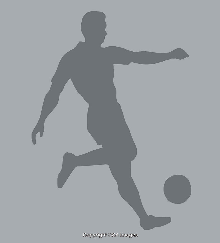 Silhouette of a Soccer Player Kicking a Ball in Action