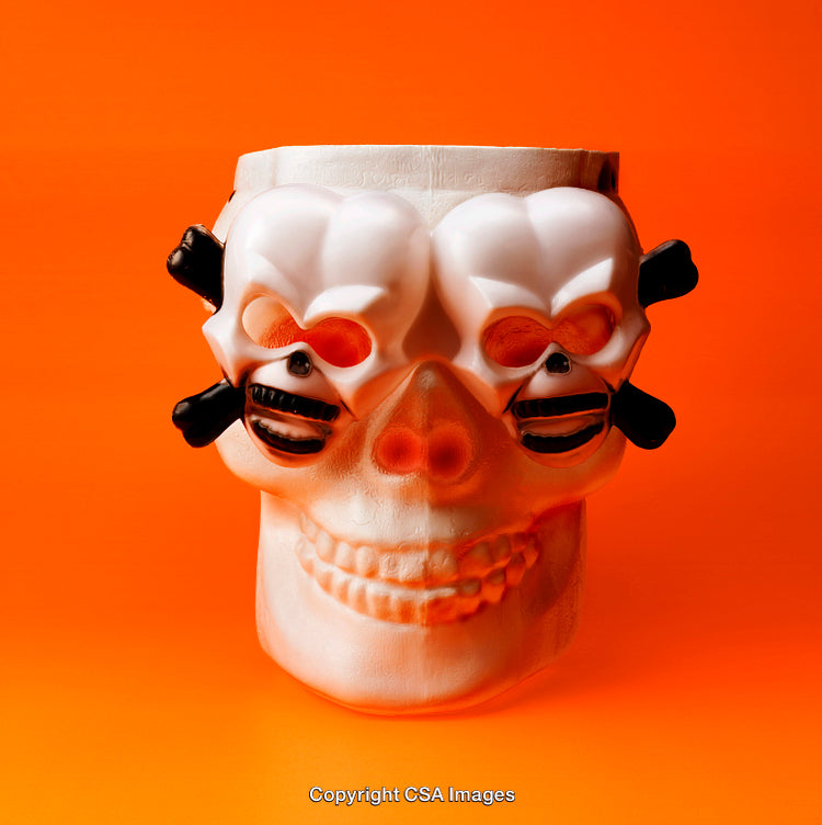 Styled Plastic Skull on Vibrant Orange Background for Halloween Celebration Themes