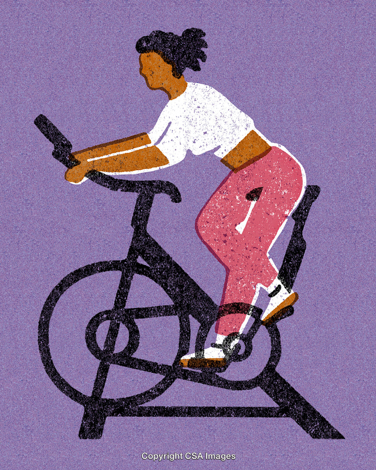 Woman Exercising on Stationary Bike in Stylish Relaxed Clothing