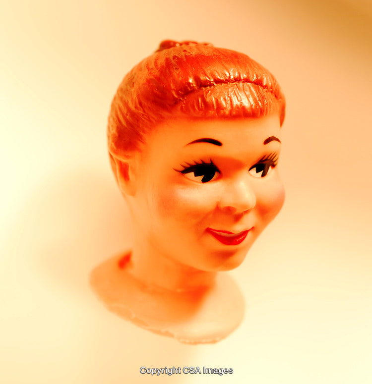 Vintage Plastic Doll Head with Orange Hair on Neutral Background