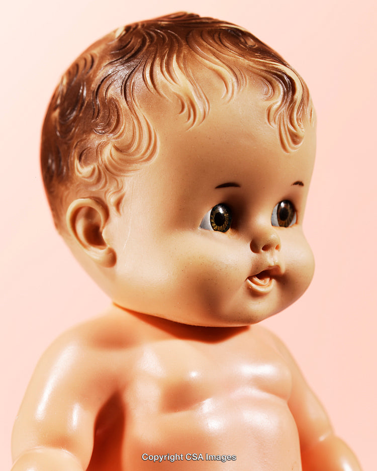 Vintage Toy Doll With Detailed Facial Features and Curly Hair On Pastel Background