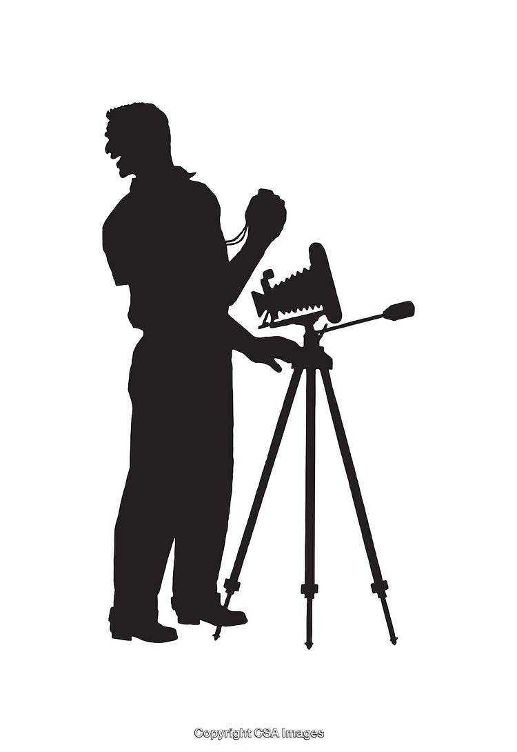 Silhouetted Photographer Operating a Vintage Camera on a Tripod