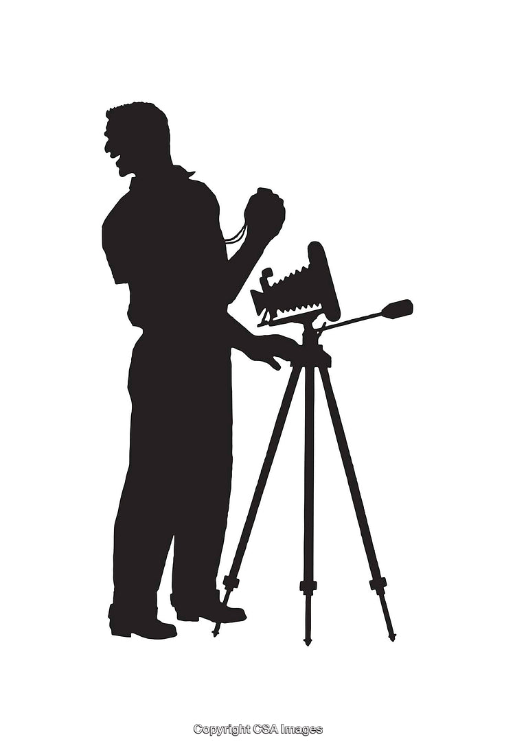 Silhouetted Photographer Operating a Vintage Camera on a Tripod