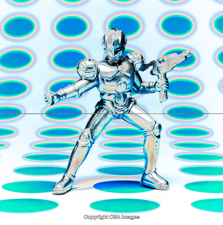Metallic Robot Toy Posed Against Vibrant Polka Dot Background