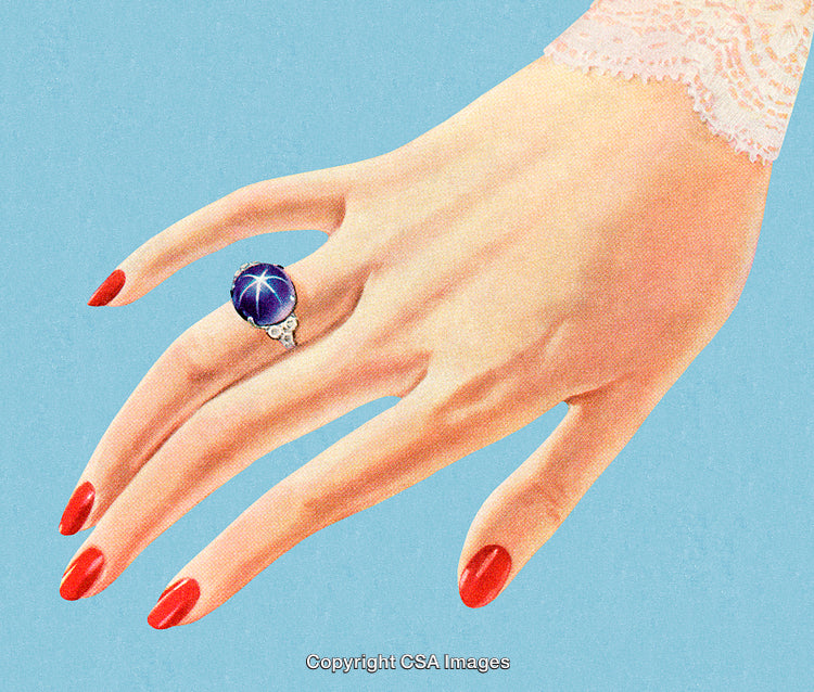 Elegant Female Hand With Blue Gemstone Ring and Red Nail Polish