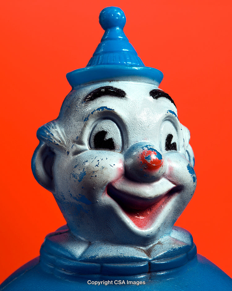 Close-Up of a Blue Vintage Clown Figure with Bright Red Background