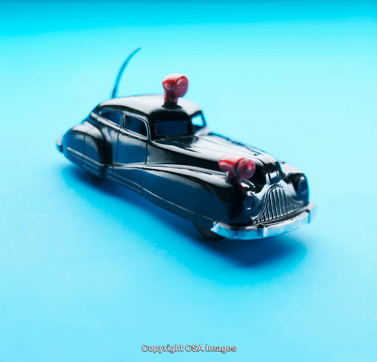 Vintage Toy Police Car on Blue Background with Red Sirens