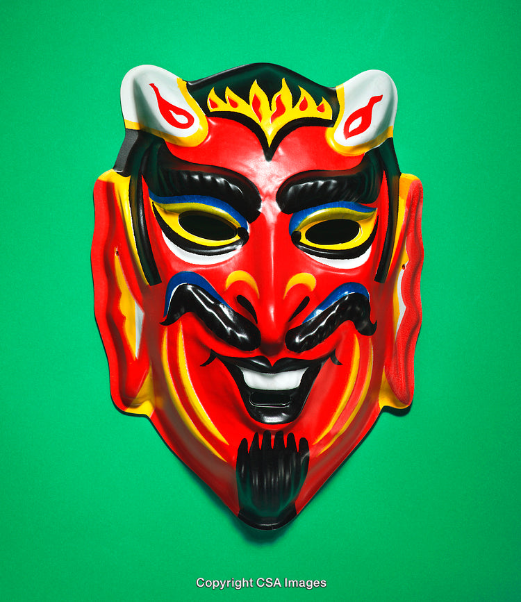 Colorful Devil Mask on Green Background Depicting Festive and Mythological Theme