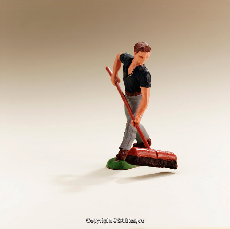 Plastic Figurine of Man Sweeping with a Push Broom on Neutral Background