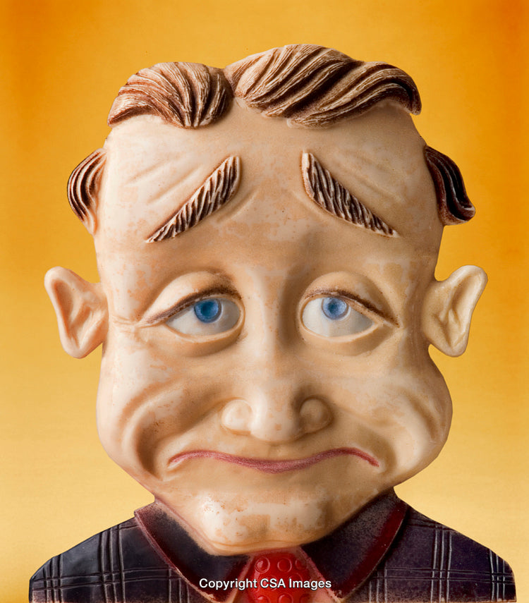 Close-Up of a Sad Expression Toy Figure on a Yellow Background