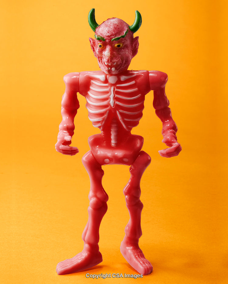 Red Plastic Toy Skeleton with Devil Horns in Bright Background
