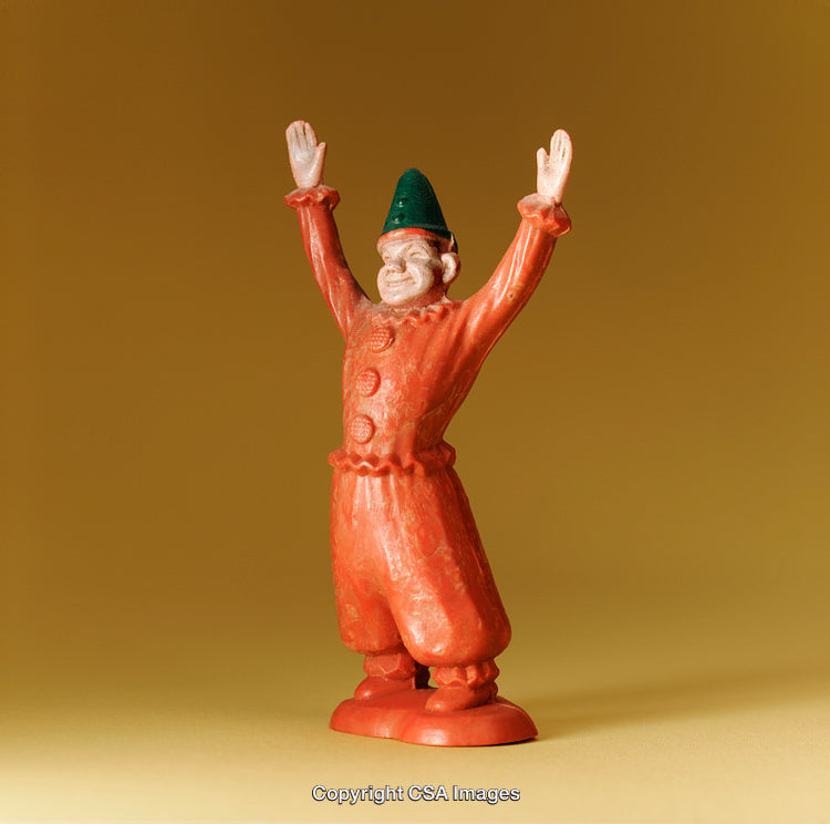 Colorful Toy Figure Dressed in Festive Attire with Raised Arms