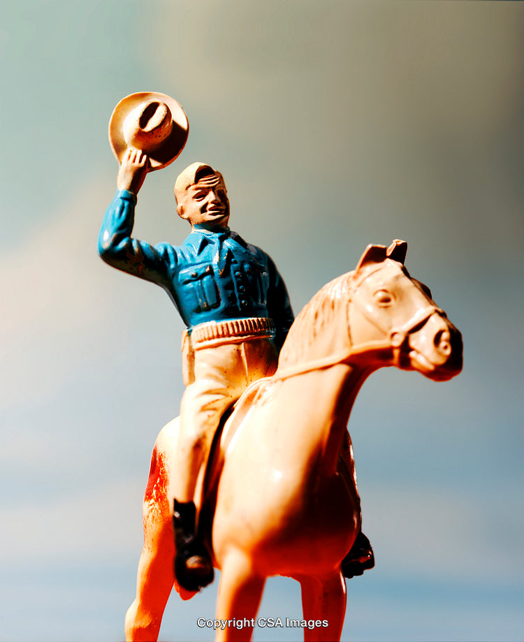 Plastic Cowboy Toy Figure Riding a Horse in a Scenic Background