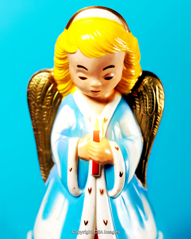 Blonde Angel Figurine Holding Candle Against Vibrant Blue Background