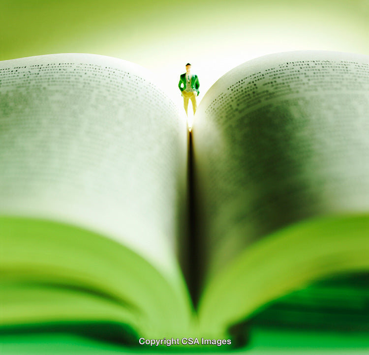 Miniature Figure Standing on a Book Symbolizing Knowledge and Imagination