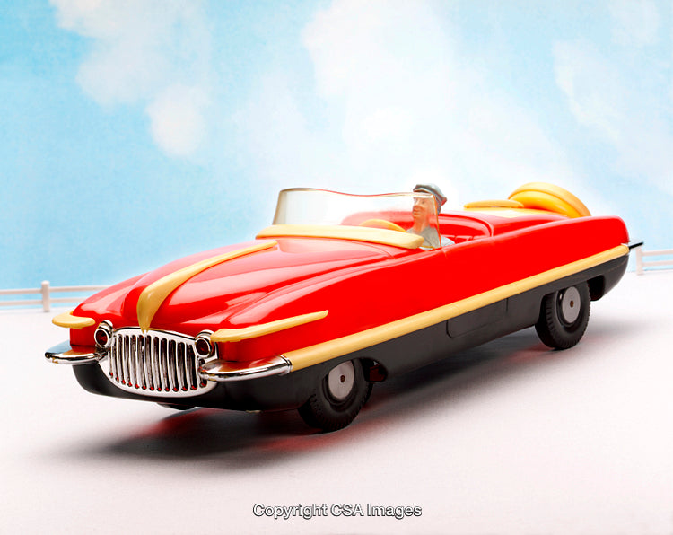 Vintage Red Convertible Toy Car with Driver Figure on Blue Background