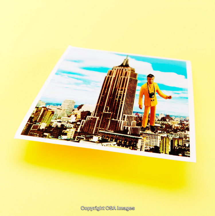 Miniature Toy Figurine Overlays a Photo of a Cityscape
