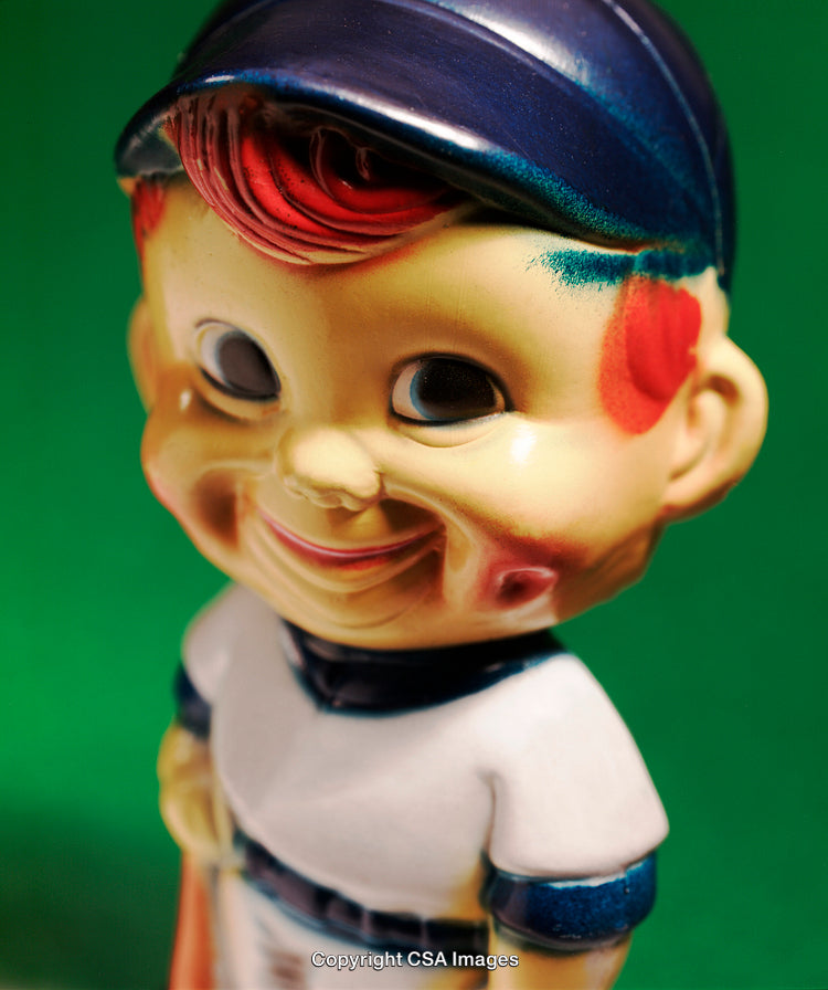 Colorful Vintage Plastic Baseball-Themed Toy with Cheerful Expression on Green Background