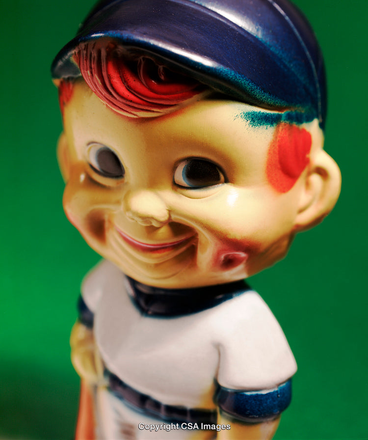 Colorful Vintage Plastic Baseball-Themed Toy with Cheerful Expression on Green Background
