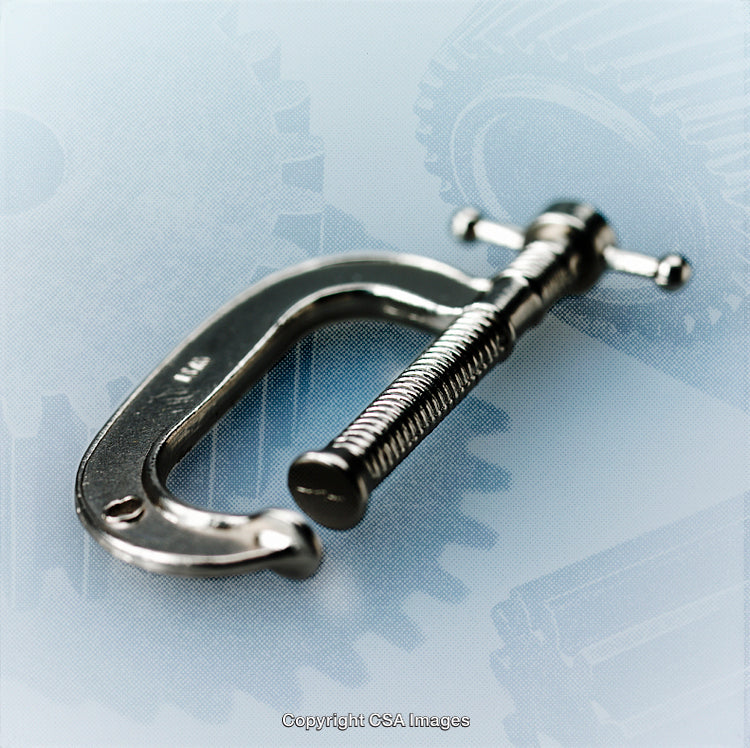Close-Up of a Metal C-Clamp on a Gear Background