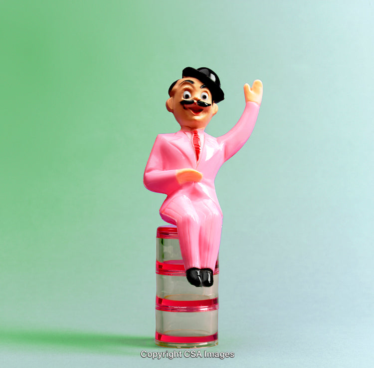 Colorful Plastic Figurine Sitting on a Decorative Surface with Green Background