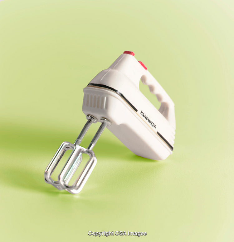 Vintage Hand Mixer Concept Against Bright Green Background with Retro Appeal