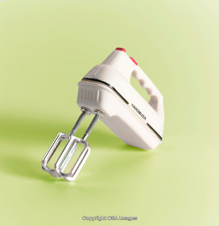Vintage Hand Mixer Concept Against Bright Green Background with Retro Appeal