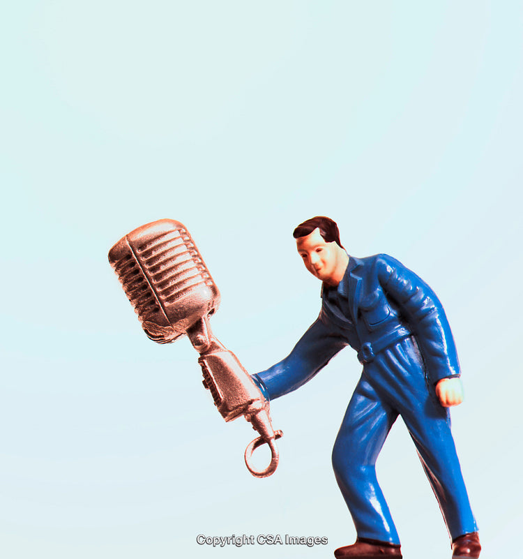 Stylized Plastic Toy Figure Holding Large Microphone on Blue Background