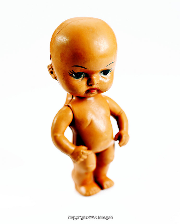 Close-Up of a Vintage Plastic Doll Against White Background