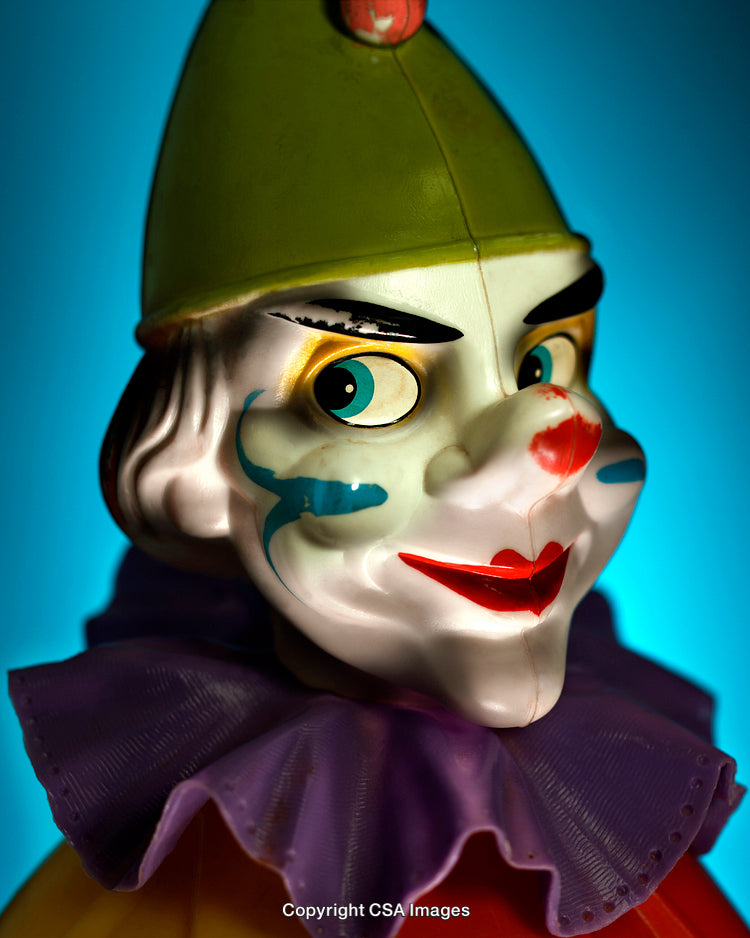 Close Up of a Colorful Vintage Clown Toy Against a Blue Background