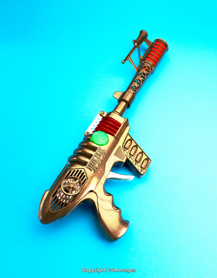 Sci-Fi Toy Ray Gun Against Bright Blue Background
