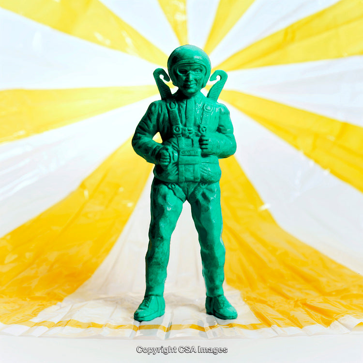 Green Plastic Soldier Figurine with Yellow and White Parachute Backdrop