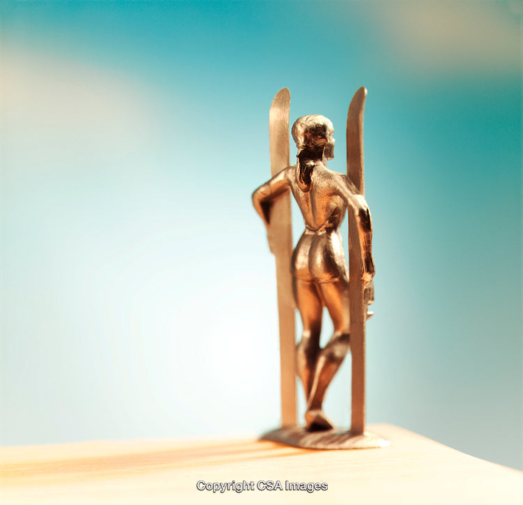 Golden Figurine of Skier Against Vibrant Blue Background
