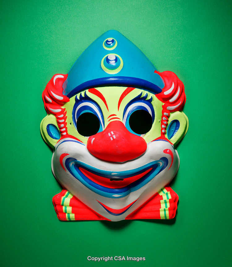 Brightly Colored Vintage Clown Mask Against a Solid Green Background