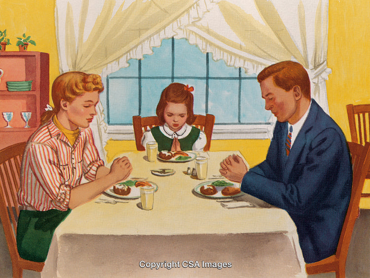 Family Praying Together Before a Meal at the Dinner Table